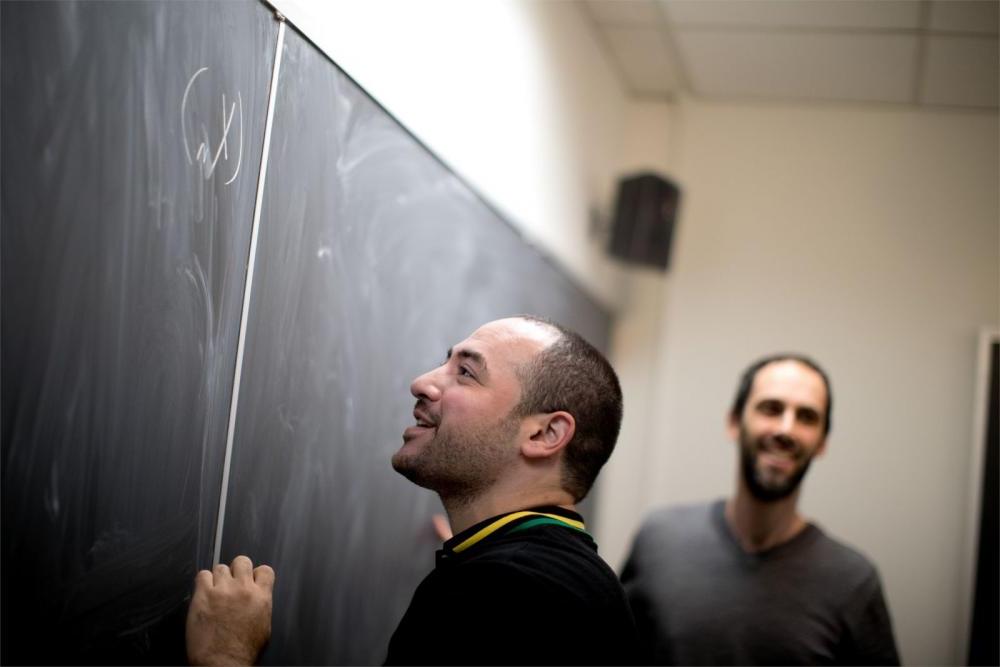  Student figuring out equations with the assistance of dedicated Temple faculty members.